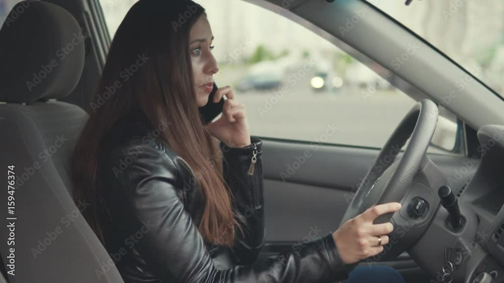 Young woman is emotionally quarreling by phone in the car Young woman is emotionally quarreling by phone in the car