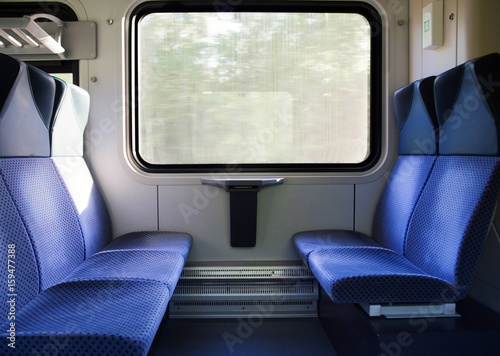 Five blue seats facing each other in modern European train