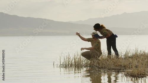 Wide shot of park rangers collecting water sample from lake. Vineyard, Utah, United States