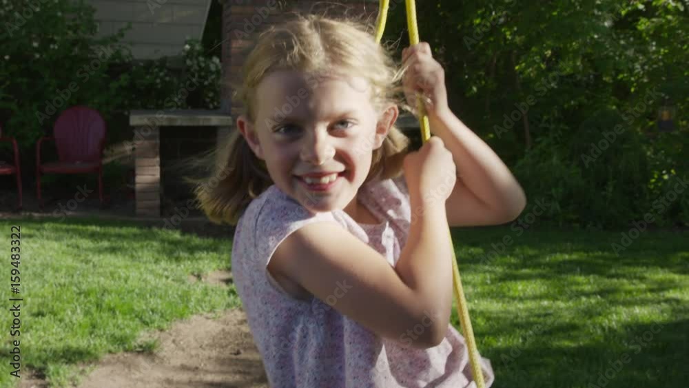Medium slow motion shot of girl looking at camera on rope swing. Springville, Utah, United States Medium slow motion shot of girl looking at camera on rope swing. Springville, Utah, United States