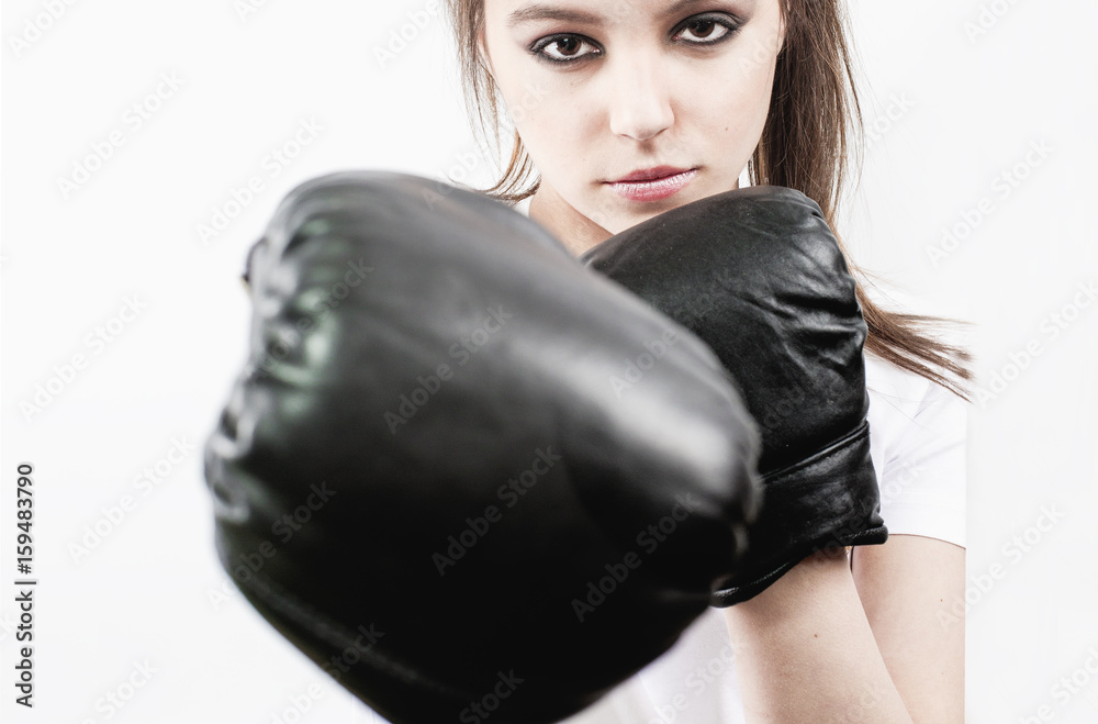 Pretty young woman wearing boxing gloves and looking at camera.