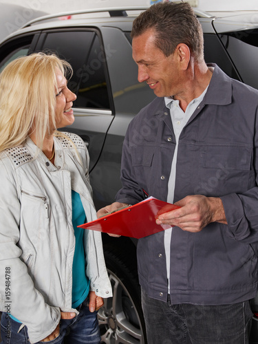 Motormechanic explaining repair costs photo