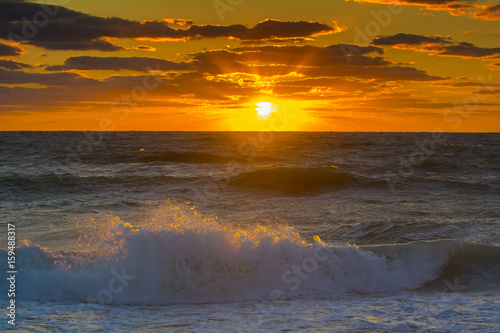ocean sunset latge golden ball setting to ocean 