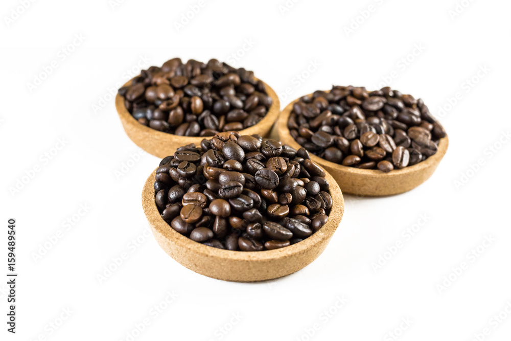 Preparing fresh roasted coffee beans in small wooden bowl on white background. Preparing fresh roasted coffee beans in small wooden bowl on white background.
