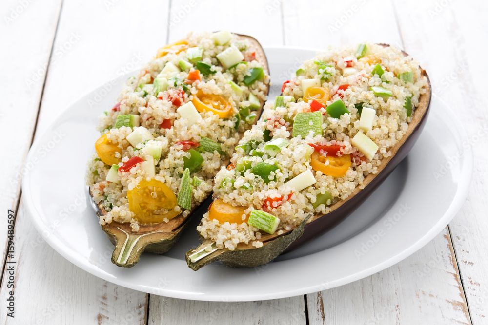 stuffed eggplant with quinoa and vegetables on white wooden table