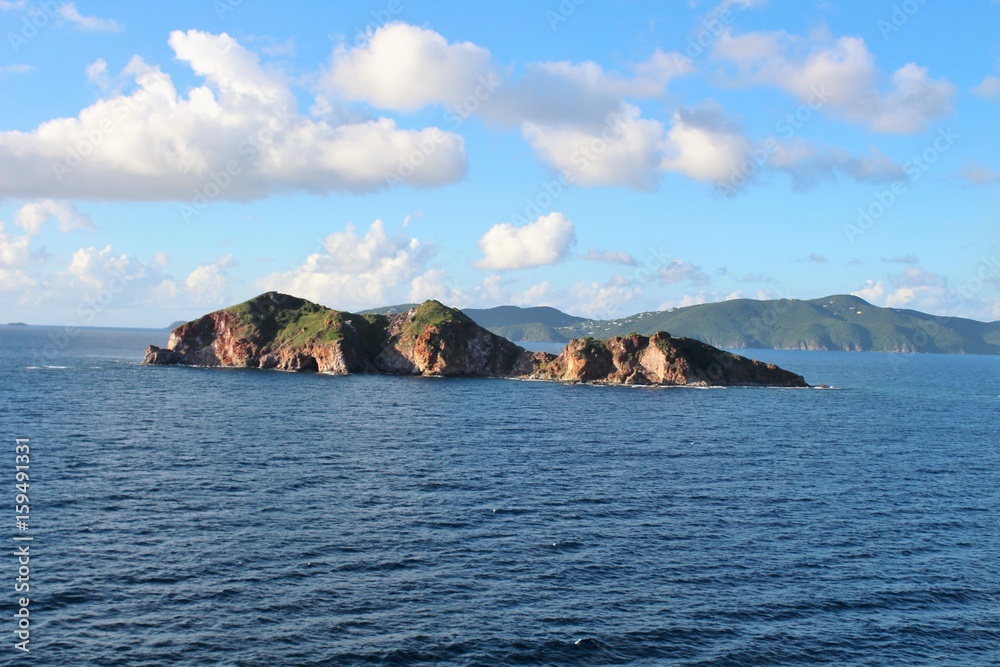 Small island off the coast of St. Thomas with clouds in the sky Small island off the coast of St. Thomas with clouds in the sky
