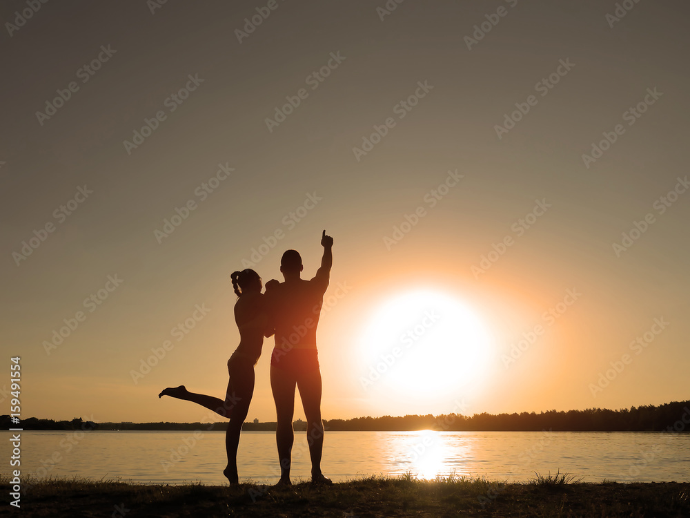 Silhouettes of a loving couple on the beach. Sunset on the beach