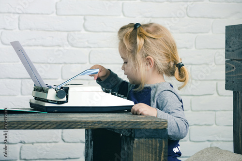 boy or small kid with typewriter and paper photo