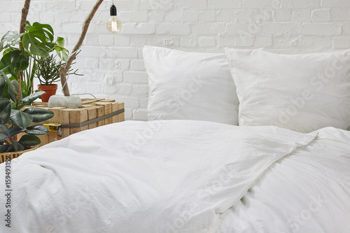 urban loft bedroom white bed linen and creative nighstand with plants