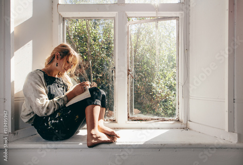 Female artist in workshop making a sketch in book