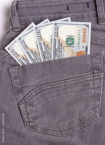 Dollars bills in black jeans back pocket.