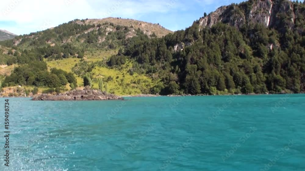 Coast of green mountain river view from boat in Patagonia Argentina. Unique landscape of wildlife. Beautiful nature background. Travel and tourism in picturesque world of stone rocks and hills. Coast of green mountain river view from boat in Patagonia Argentina. Unique landscape of wildlife. Beautiful nature background. Travel and tourism in picturesque world of stone rocks and hills.
