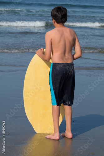 Kid waiting right wave to laun surfboard