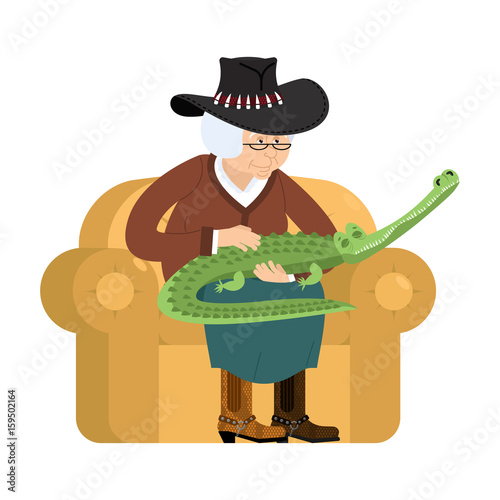 Australian grandmother and crocodile. Australia old woman and an alligator pet. grandma in hat on couch. Crocodile farm. gammer breeds wild reptiles and predators