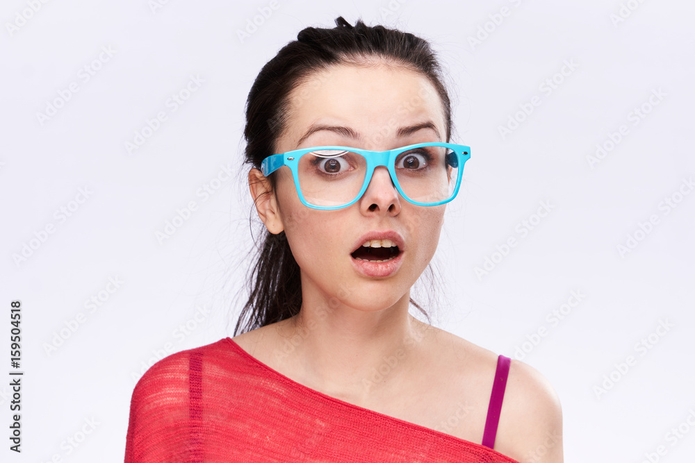 Surprised woman with glasses on the side on a light background Surprised woman with glasses on the side on a light background
