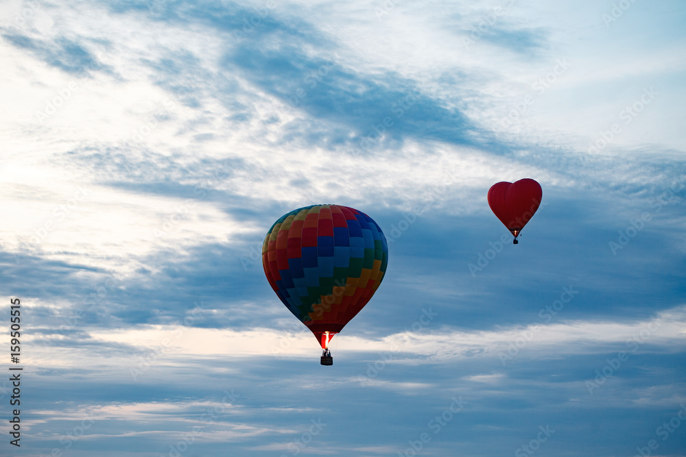 Fototapeta premium Colorful hot air balloon is flying at sunrise