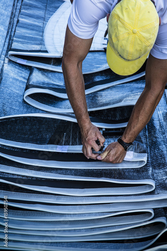 man works on sails for 12 metre North American Championships racing in Newport RI.