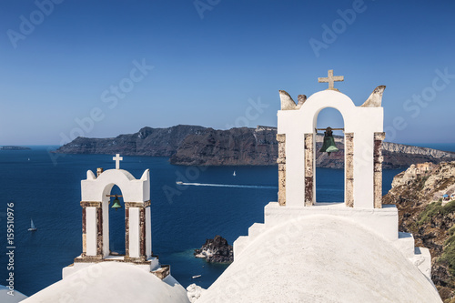 The bell tower Greek Orthodox Church in the small town of Oia in Santorini, Greece on the background of the Aegean sea