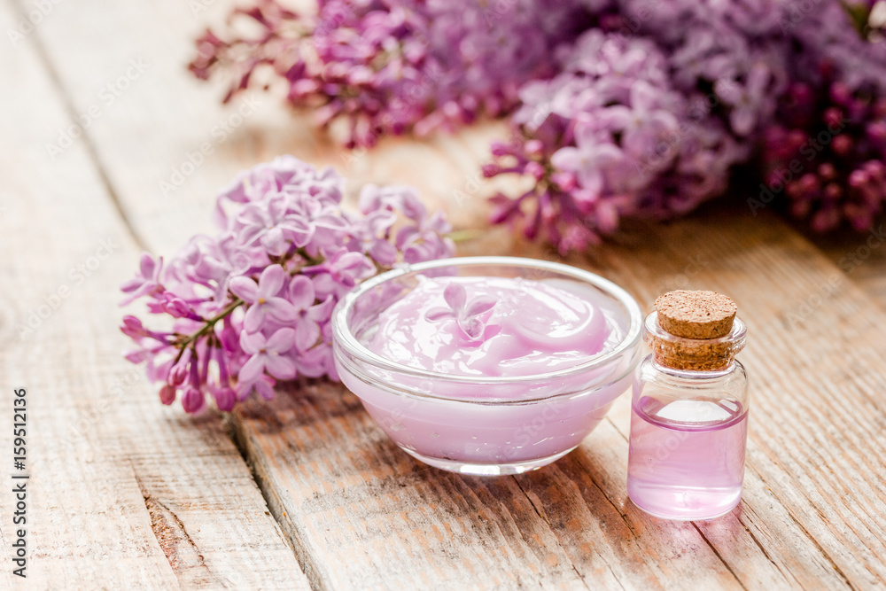 organic cream, extract in lilac cosmetic set with flowers on wooden table background organic cream, extract in lilac cosmetic set with flowers on wooden table background