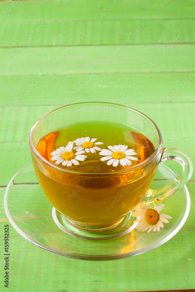 Herbal tea with fresh chamomile flowers on green wooden background with copy space for your text Herbal tea with fresh chamomile flowers on green wooden background with copy space for your text