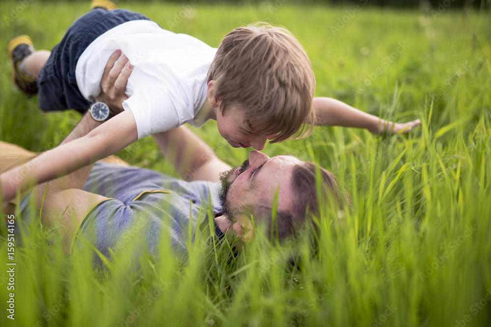 Father and son having fun outdoors in the meadow Father and son having fun outdoors in the meadow