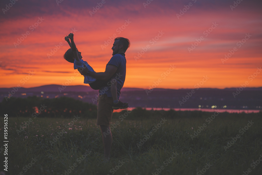 Fototapeta premium silhouette of father and son at sunset