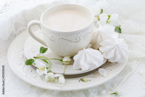 Porcelain cup of tea with milk on white background