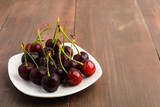 Many healthy cherries on white plate
