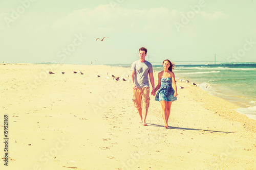 Young American Couple walking, relaxing on the beach in New Jersey, USA