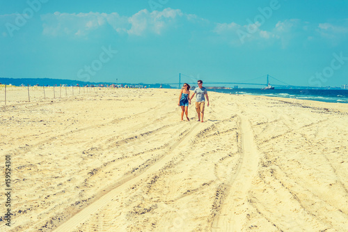 Young couple walking, relaxing on the beach in New Jersey, USA