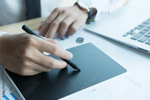 young graphic designer working with computer. creative man using digital tablet and stylus pen at modern office. business, technology, design and people concept photo