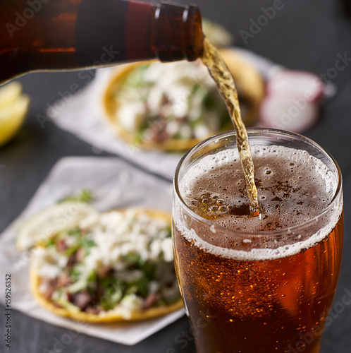 pouring beer in front of mexican tacos