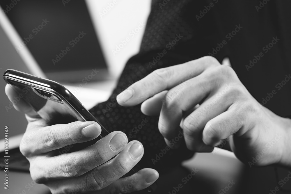 close up of businessman hand working with mobile phone and laptop and digital tablet computer in modern office