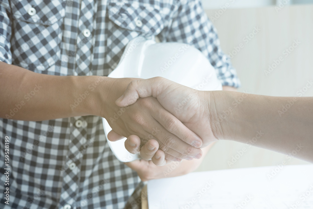 Architect and customer shaking hands at workplace. Engineer handshaking with partner for successful deal in building project development. business teamwork, cooperation, success collaboration concept