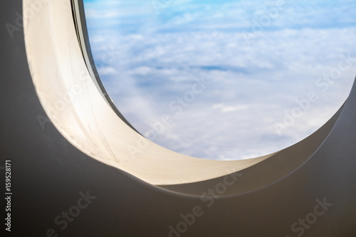 Close up airplane window when flying see through at cloud and blue sky,Transportation,Travel concept