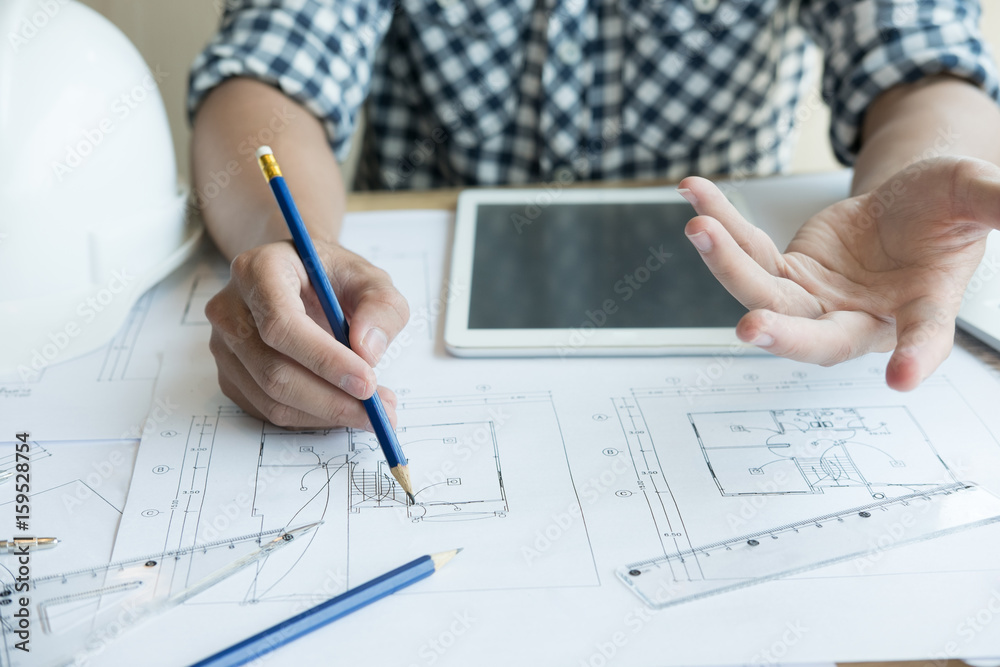 Architect working on real estate project at workplace. Male engineer hand working with living house blueprint at office. Business, people, construction and building concept Architect working on real estate project at workplace. Male engineer hand working with living house blueprint at office. Business, people, construction and building concept