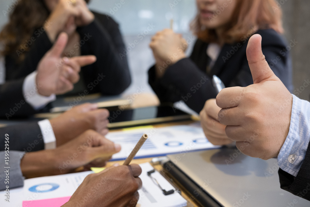 young business people having a meeting in office. businessman show thumb up gesture. businesswoman working at workplace.  Conference, discussion, teamwork, collaboration, corporate concept.