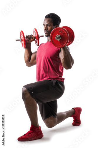 Muscular sexy young black man exercising shoulders and legs with dumbbells, isolated on white in studio shot