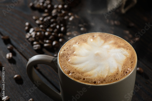 capucino foam in coffe cup, coffee beans in the dark background © rafciu1988