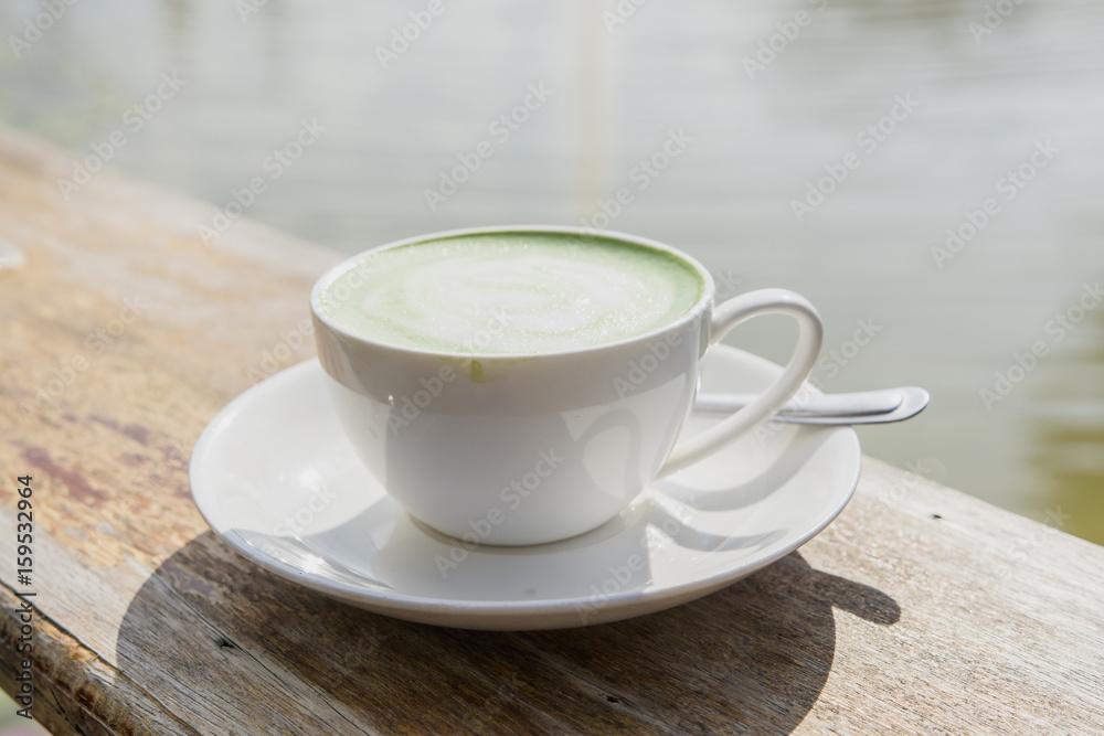 Green tea, milk, hot on wood near the pond. Green tea, milk, hot on wood near the pond.