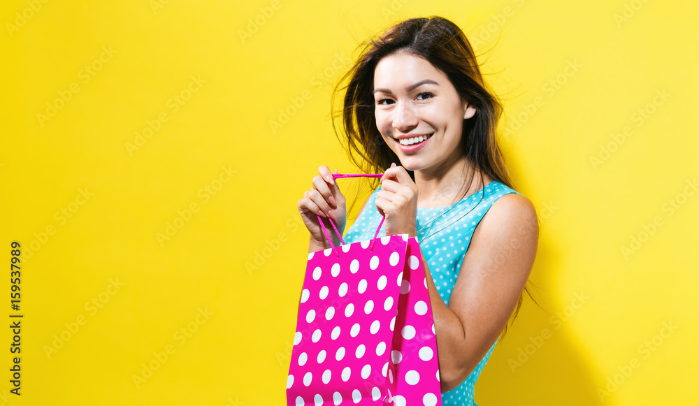  Happy young woman holding a shopping bag