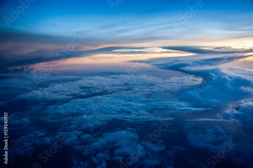 Aerial view of a cloudy sunset while flying above the clouds © lmanju