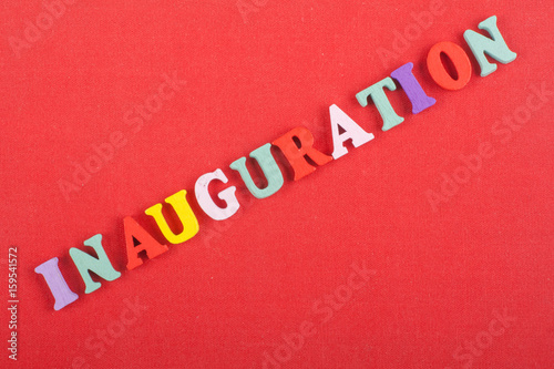 Iinauguration . English word on red background composed from colorful abc alphabet block wooden letters, copy space for ad text. Learning english concept.