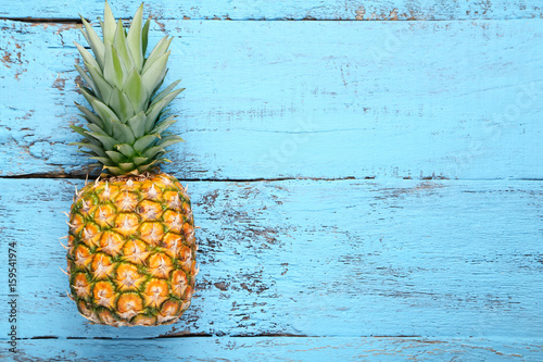 Ripe pineapple on blue wooden table