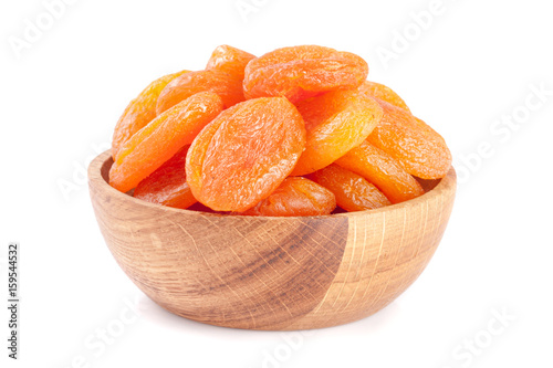 Dried apricots in a wooden bowl isolated on white background