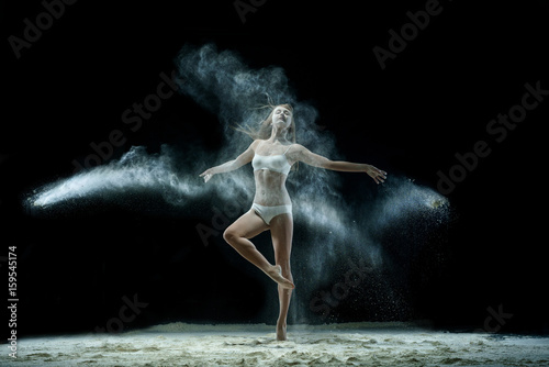 Fototapeta Naklejka Na Ścianę i Meble -  Girl in a cloud of white dust studio portrait