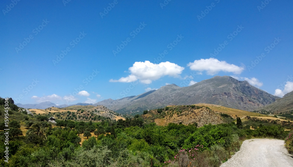 The view towards the Kourtaliotiko gorge in Crete. Mountains, fields, trees and road