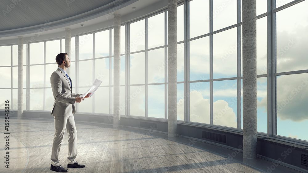 Fototapeta premium Businessman in modern office interior . Mixed media