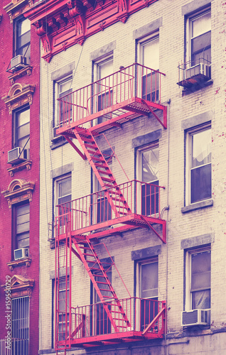 Vintage toned photo of a residential building fire escape in Manhattan, New York City, USA.
