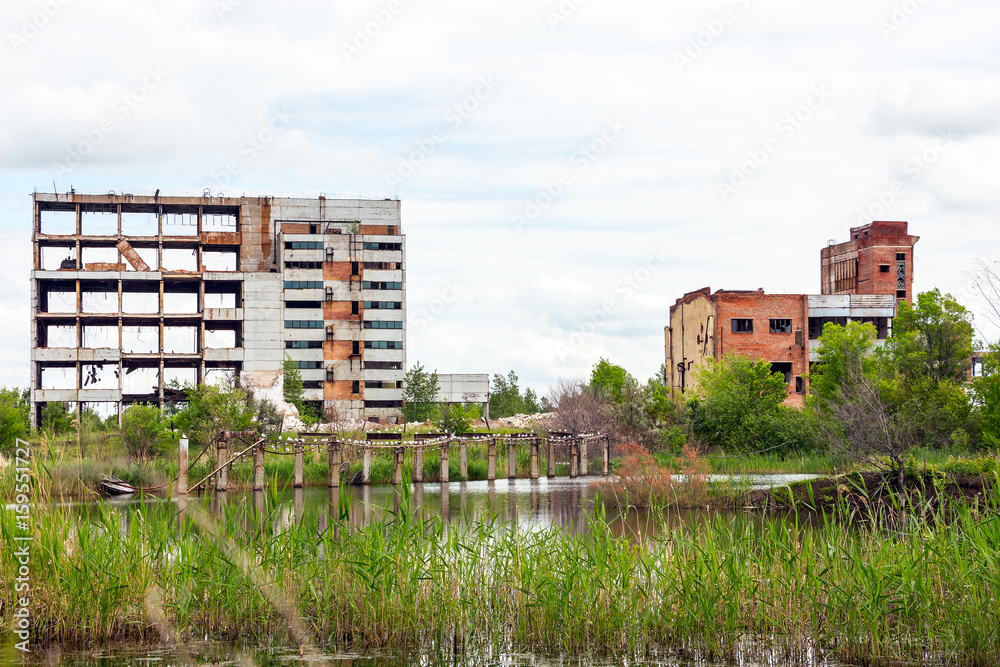 The abandoned building is located among the trees. There is a pond in front of the building. This is a former factory or office The abandoned building is located among the trees. There is a pond in front of the building. This is a former factory or office